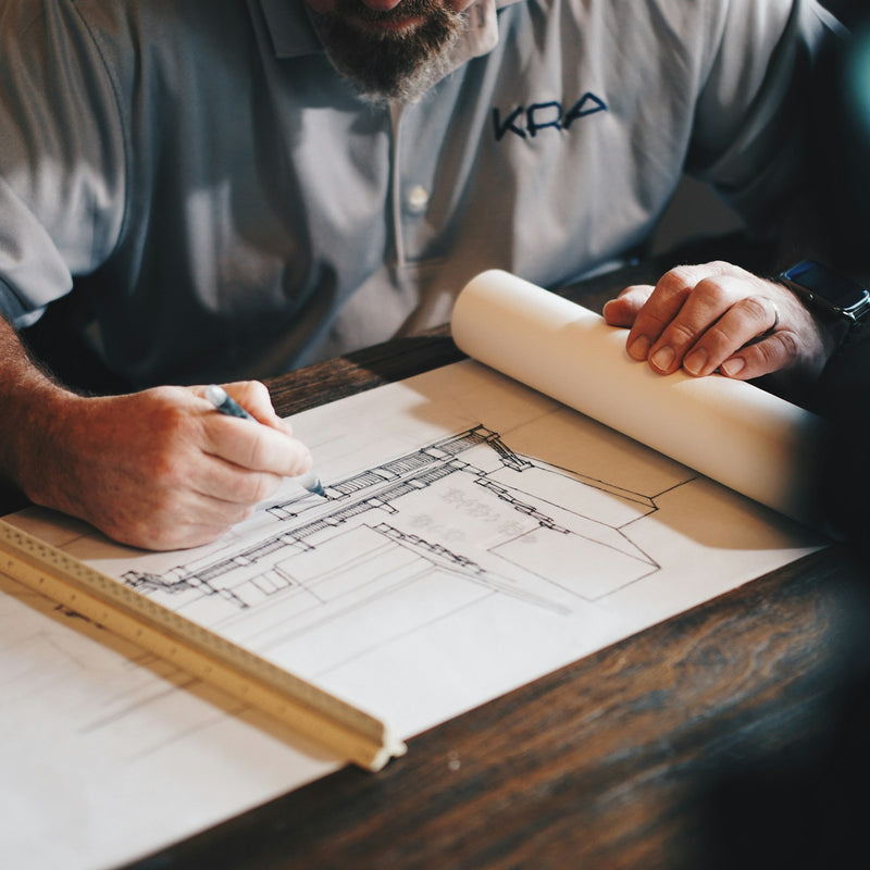 Room planner kit: furniture floor plan templates being drawn on paper
